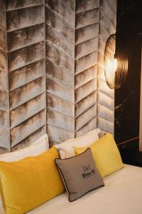Habitación con sofá y almohadas amarillas. en White Hill Hotel, SPA & Conferences en Durrës