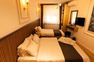 ein Hotelzimmer mit 2 Betten und einem TV in der Unterkunft GRAND İŞBİLİR HOTEL in Nevşehir