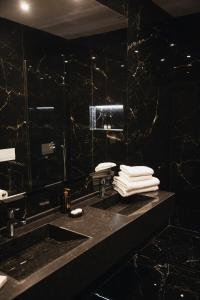 Baño negro con lavabo y espejo en White Hill Hotel, SPA & Conferences, en Durrës