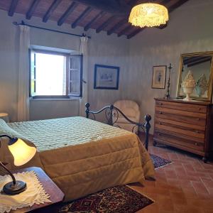 ein Schlafzimmer mit einem Bett, einer Kommode und einem Fenster in der Unterkunft Villa with swimming pool, fenced, 10 bed places Toscana wi-fi in Serre di Rapolano