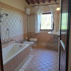 ein Badezimmer mit einer Badewanne, einem WC und einem Waschbecken in der Unterkunft Villa with swimming pool, fenced, 10 bed places Toscana wi-fi in Serre di Rapolano