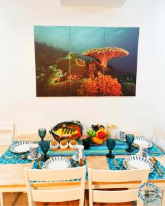 einen Esstisch mit einem großen Gemälde eines Regenschirms in der Unterkunft Azure Urban Resort Residence in Manila