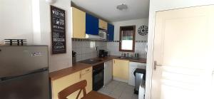a small kitchen with a refrigerator and a sink at Joli triplex 3 étoiles, avec jardin et cheminée in Génos