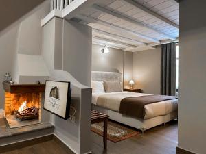 a bedroom with a bed and a fireplace at Ef Zin Hotel Arachova in Arachova