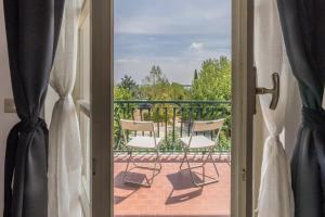 a sliding glass door with two chairs on a patio at Appartamento Campiello in Sirmione