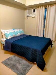 a bedroom with a bed with a blue blanket on it at Avida Towers Riala, Tower 2 in Cebu City