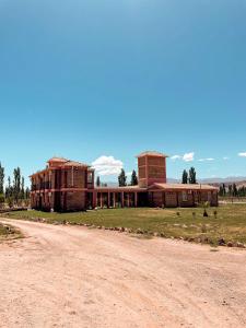 um edifício antigo na lateral de uma estrada de terra em Posada Villa Pituil em Barreal