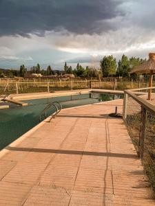 einen Wasserpool auf einem Feld mit einem Zaun in der Unterkunft Posada Villa Pituil in Barreal