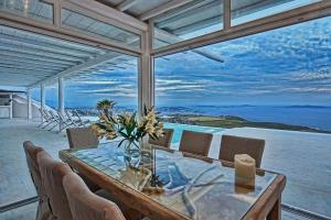 comedor con mesa y vistas al océano en Magnificent Mykonos Villa - Villa Blue Paradise - 8 Bedroom - Private Pool And Bar - Panoramic SeaViews, en Fanari