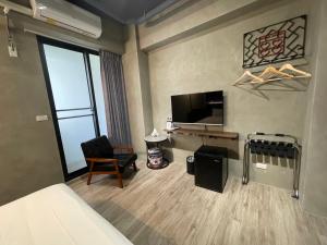 Camera con letto, TV e sedia di Long Lang Homestay a Tainan