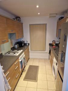 a kitchen with wooden cabinets and a stove top oven at KO 3 bed house in Kent