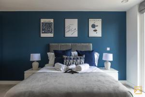 ein Schlafzimmer mit blauen Wänden und einem großen Bett in der Unterkunft Cosy 1 bed near peaceful canal By Valore Property Services in Milton Keynes