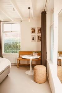 una camera da letto con tavolo, letto e finestra di Boutiquehotel & Tiny houses PLEK17 a Milsbeek