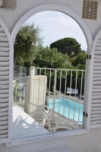 an arched window with a view of a swimming pool at Hotel La Voile in Bormes-les-Mimosas