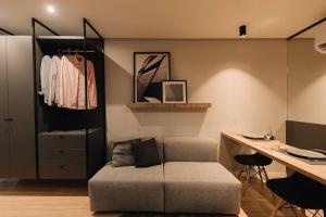 a room with a chair and a desk and a closet at Loft perfeito no Parque Una com garagem in Pelotas
