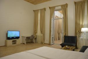 a hotel room with a television and a living room at Tovstonogovi Street Apartment in Tbilisi City