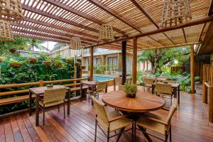 un patio esterno con tavoli, sedie e piscina di Vila Sal Noronha a Fernando de Noronha