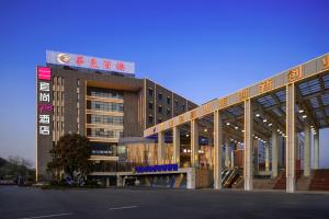 um grande edifício com uma placa em cima em Echarm Plus Hotel - Foshan Smart New City Zhangcha Metro Station Branch em Foshan