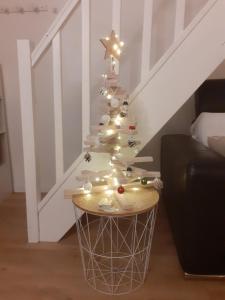 a white christmas tree with lights on a table at petite maison cosy avec exterieur in Marseille