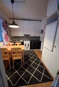 una cucina con tavolo e una cucina con armadietti bianchi di NORVALA The shower is located in the main building a Rovaniemi