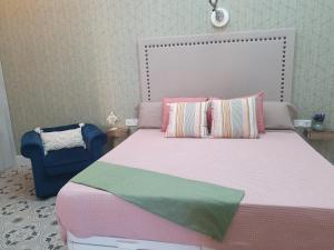 - une chambre avec un lit et une chaise bleue dans l'établissement Apartamento Jema El Bajondillo, à Torremolinos