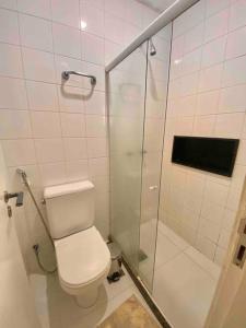 a bathroom with a toilet and a glass shower at Ocean Flat 607 in Vila Velha +16 photos
