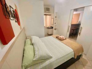 a small bedroom with a bed in a room at Ocean Flat 607 in Vila Velha