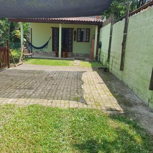 a house with a brick walkway in front of it at Casinha Mar e Sol Boiçucanga in São Sebastião +3 photos
