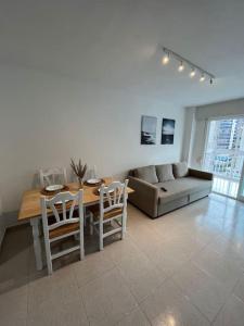 sala de estar con sofá, mesa y sillas en APTO RESIDENCIAL EN BENICASIM, en Benicàssim