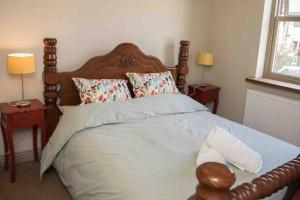 a bedroom with a large bed with a wooden headboard at 3 George Street Addingham in Addingham