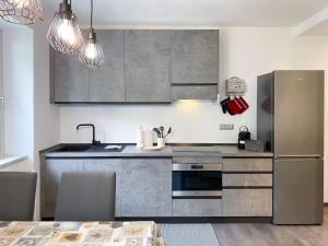 a kitchen with stainless steel appliances and a table at Angel's Home 1 in Ponte di Legno