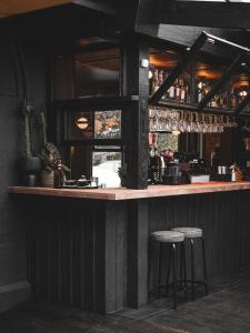 a bar with two stools sitting at a counter at Deus Lodge of Heavy Leisure in Bournemouth