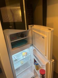 - un réfrigérateur vide avec une porte ouverte dans la cuisine dans l'établissement Charmant studio fonctionnel, à Paris