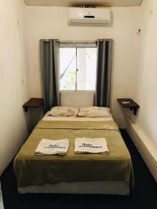 a small bedroom with a bed with two towels on it at Hostel Jericoacoariano in Jericoacoara
