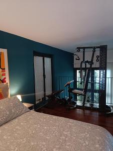 sypialnia z łóżkiem oraz siłownia z bieżniami w obiekcie Loft Certosa District con parcheggio privato w Mediolanie