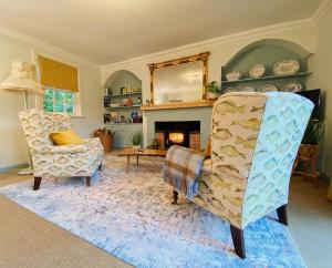 a living room with two chairs and a fireplace at River Cottage in Turriff