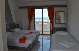 two beds in a room with a view of the ocean at Oleander Studios in Faliraki