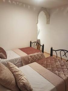 a room with two beds and an archway in it at Relaxed garden apartment with Galilee sea view 1 in Safed