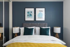 1 dormitorio con paredes azules y 1 cama con 2 lámparas en Central 1-Bed perfect for you By Valore Property Services en Milton Keynes