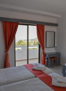 a bedroom with a bed and a window with a piano at Oleander Studios in Faliraki