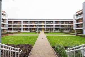 a large building with a garden in front of it at Central 1-Bed perfect for you By Valore Property Services in Milton Keynes