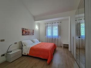 a white bedroom with a bed and a glass shower at Villa Rosa in Latronico