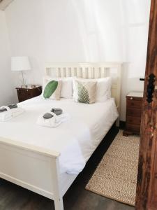 uma cama branca com dois copos em cima em Casa Dos Galegos em Marvão