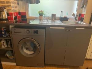 uma cozinha com uma máquina de lavar roupa e um lavatório em Charmant studio fonctionnel em Paris