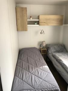 Habitación pequeña con 2 camas en una habitación en camping les sables du midi en Valras-Plage