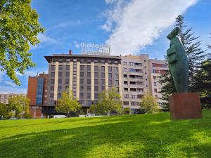 eine Statue auf einem Feld vor einem Gebäude in der Unterkunft Occidental Pamplona in Pamplona