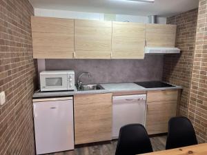 a small kitchen with a sink and a microwave at Apartamento Rodrinsur Edificio Ginebra con Parking Privado in Sierra Nevada