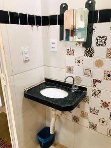 ein Bad mit einem Waschbecken und einem Spiegel in der Unterkunft Hostel Jericoacoariano in Jericoacoara