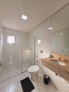 a bathroom with a toilet and a sink and a shower at Smart Hotel Joinville in Joinville