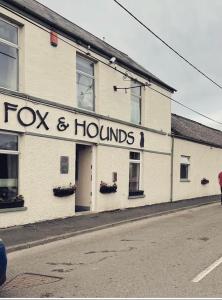 a building with a fox and hounds sign on it at The Fox and Hounds in Banc-y-felin